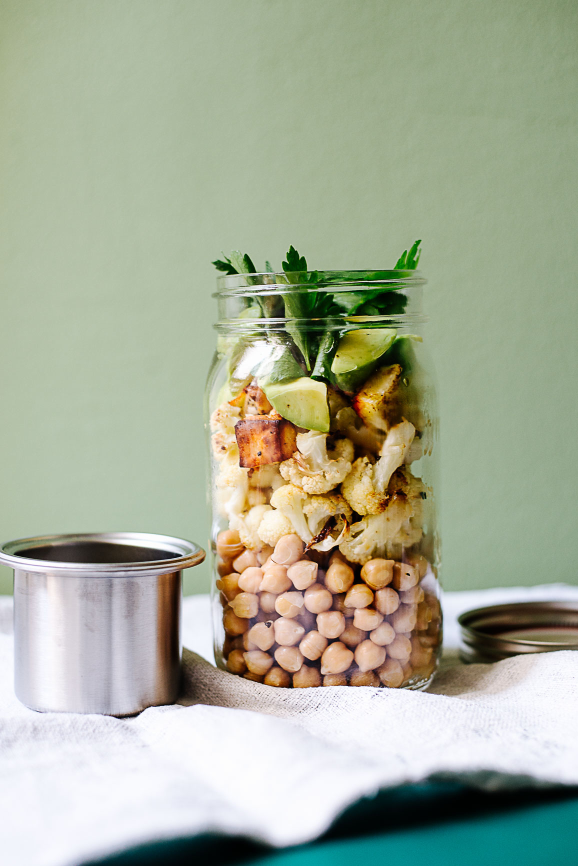 Kichererbsen mit geröstetem Blumenkohl, Avocado und Halloumi im Glas